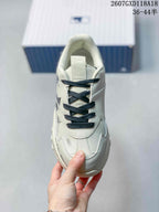 Front view of the sneaker showing the layered toe box, dark laces, and padded collar.