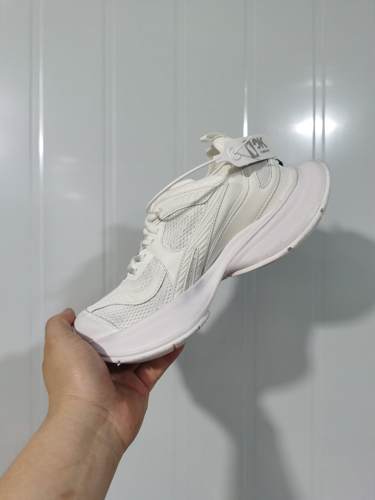 Angled view of the white Balenciaga Circuit sneaker showing layered panels, mesh sections, laces, and sculpted sole.