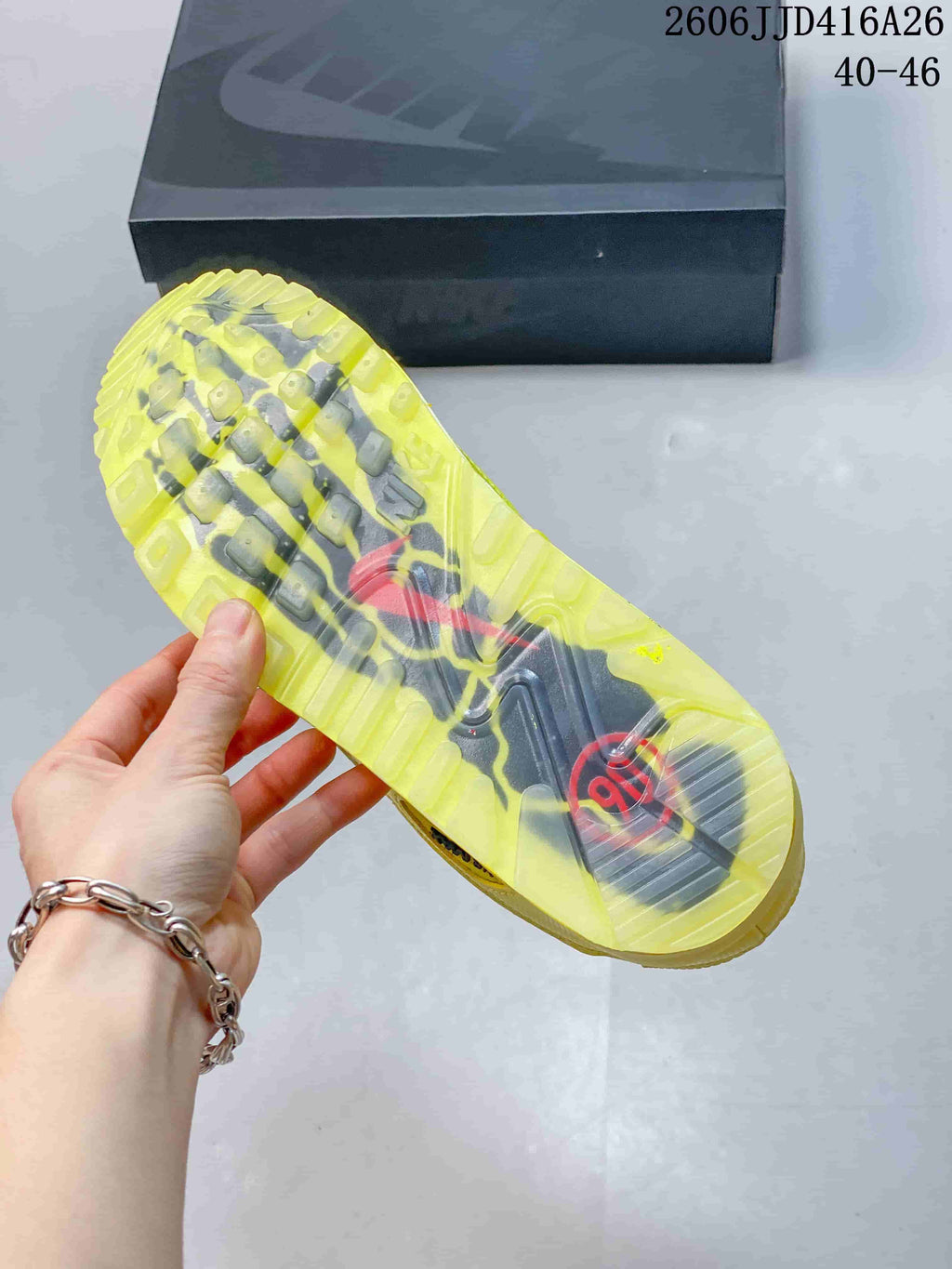 Bottom view of a Nike Air Max 90 sneaker showing the translucent yellow and dark patterned outsole.