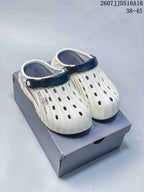 White and navy Balenciaga clogs with perforated uppers and rear straps displayed on a box; image text shows style code 2607JJD516A16 and size range 38–45.