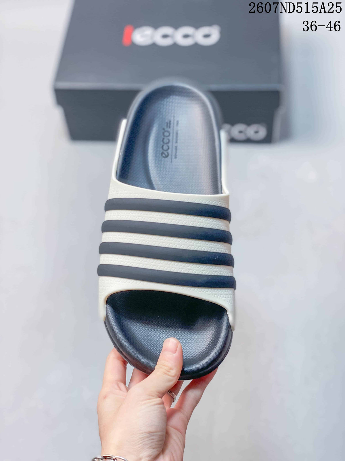 Top view of a navy and white slide sandal showing the open toe, textured footbed, and horizontal upper bands.