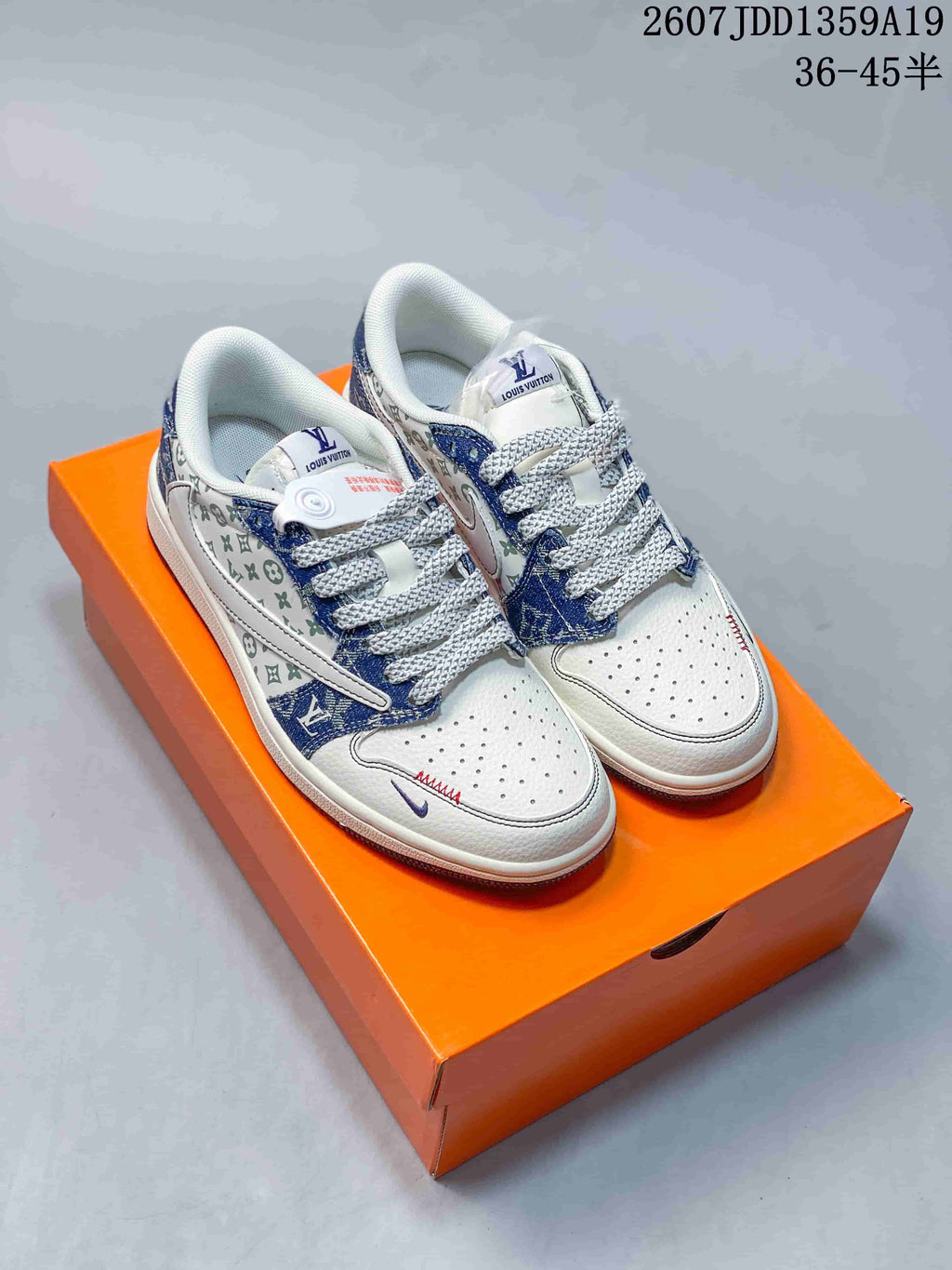 Pair of white and blue low-top sneakers displayed on an orange shoebox, with patterned side panels and contrast laces.