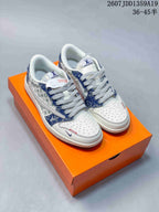 Pair of white and blue low-top sneakers displayed on an orange shoebox, with patterned side panels and contrast laces.