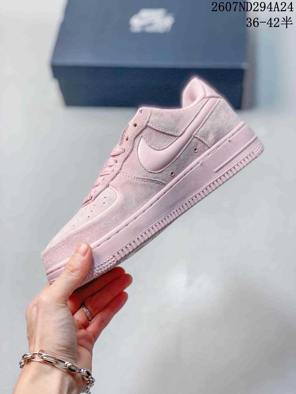 Side profile of the soft pink low-top sneaker showing the Swoosh, layered panels, and textured outsole.