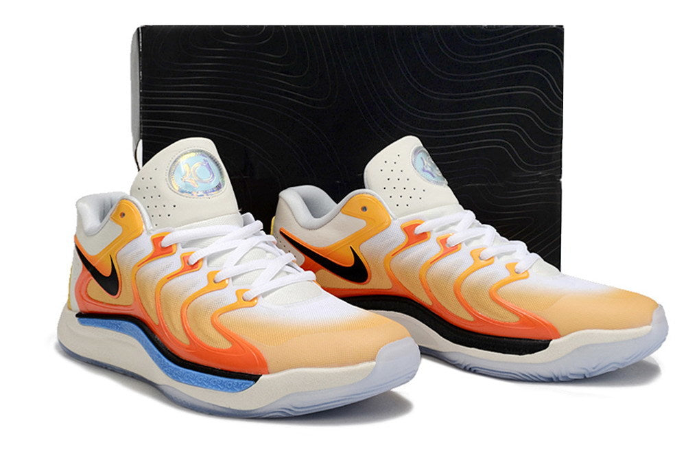 Pair of Nike KD 17 shoes in white with orange and yellow accents.