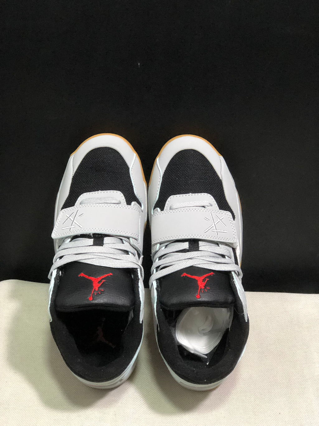Top view showing white laces, forefoot straps, black toe panels, and red tongue branding.
