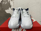Front view of white and navy Nike sneakers with white laces.