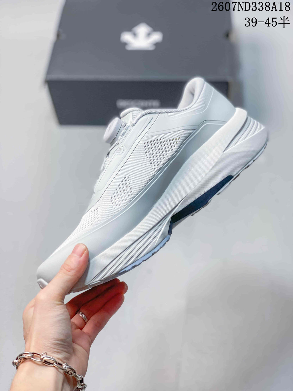 Side view of the white low-top sneaker showing the mesh panels, layered upper, and sculpted midsole.