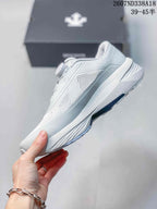 Side view of the white low-top sneaker showing the mesh panels, layered upper, and sculpted midsole.
