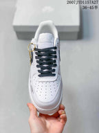 Top view of a white sneaker with black laces, perforated toe panel, and a white tongue label.