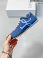 Side profile of the blue sneaker showing layered panels, a light-blue Loewe motif, white laces, and a gum outsole.