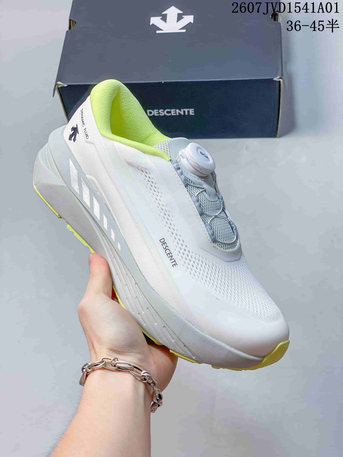 Side view of a white Descente running shoe with lime accents and dial closure.