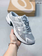 Angled side view of the white and silver ASICS Gel-1130 sneaker with layered overlays and dark outsole accents.