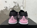 Rear view of pink and black low-top basketball shoes showing patterned heel panels and pink heel accents.