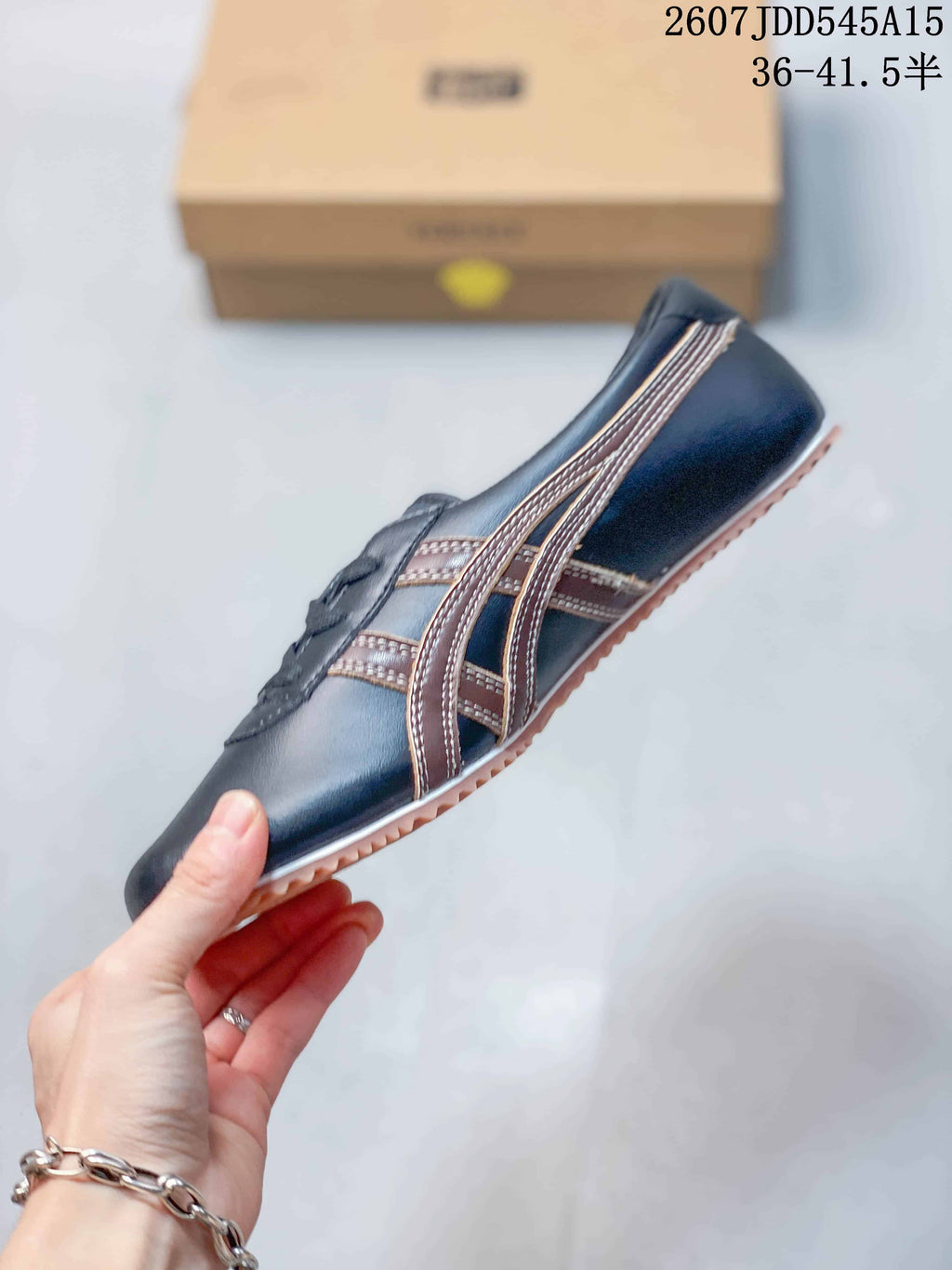 Side profile showing the navy upper, layered brown side stripes, lace-up front, and salmon outsole.