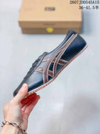 Side profile showing the navy upper, layered brown side stripes, lace-up front, and salmon outsole.
