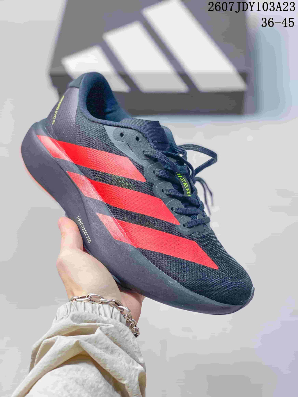Black adidas Adizero low-top sneaker with bright red side stripes and a dark sole.