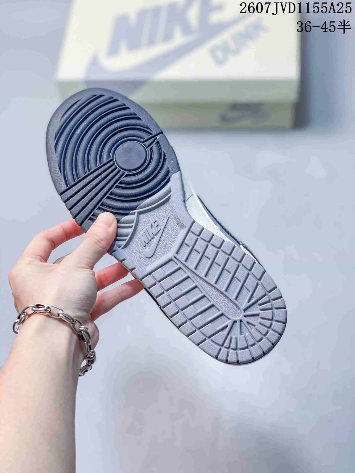 Underside view of the sneaker showing a dark navy and grey circular-pattern rubber outsole with Nike branding.