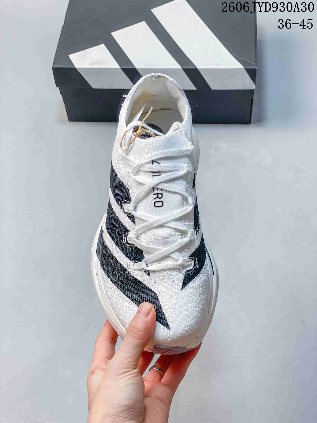 Front view showing the laces and dark stripe details on a white adidas Adizero Prime X3 shoe.