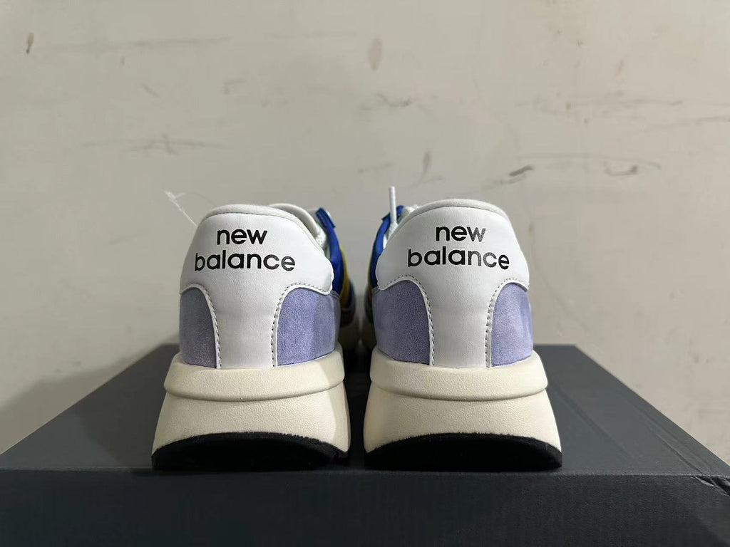 Rear view of New Balance U370 sneakers showing white heel panels and gray accents