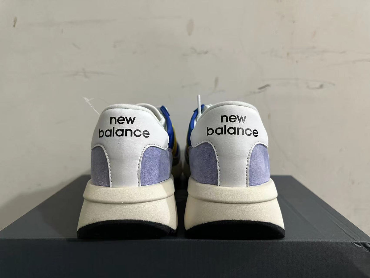 Rear view of New Balance U370 sneakers showing white heel panels and gray accents