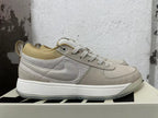 Side view showing the Swoosh and textured panels on a cream Nike Book 1 sneaker