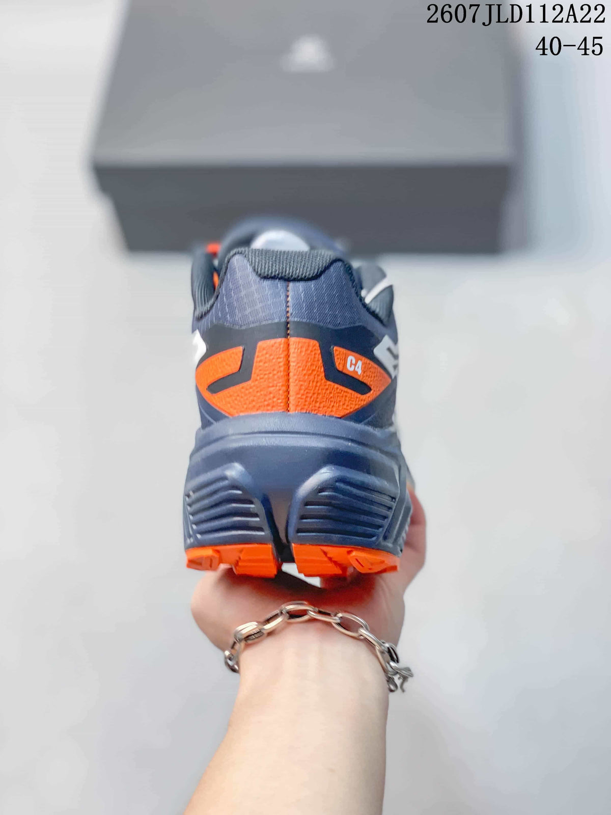 Rear view of the Kailas C4 sneaker showing the navy heel, orange accent panel, and segmented outsole.