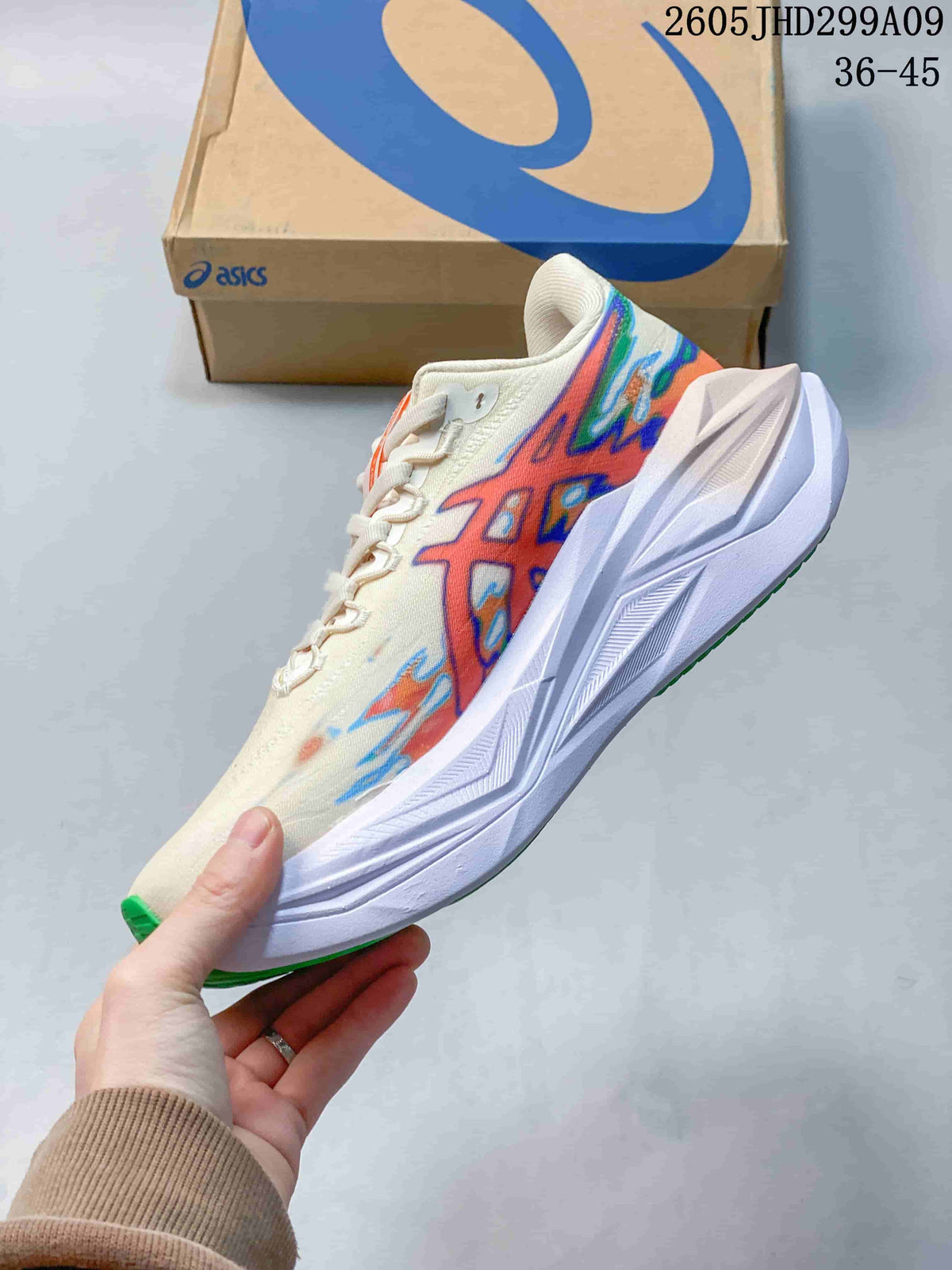 Side view of the cream running shoe with multicolor graphics and sculpted white sole