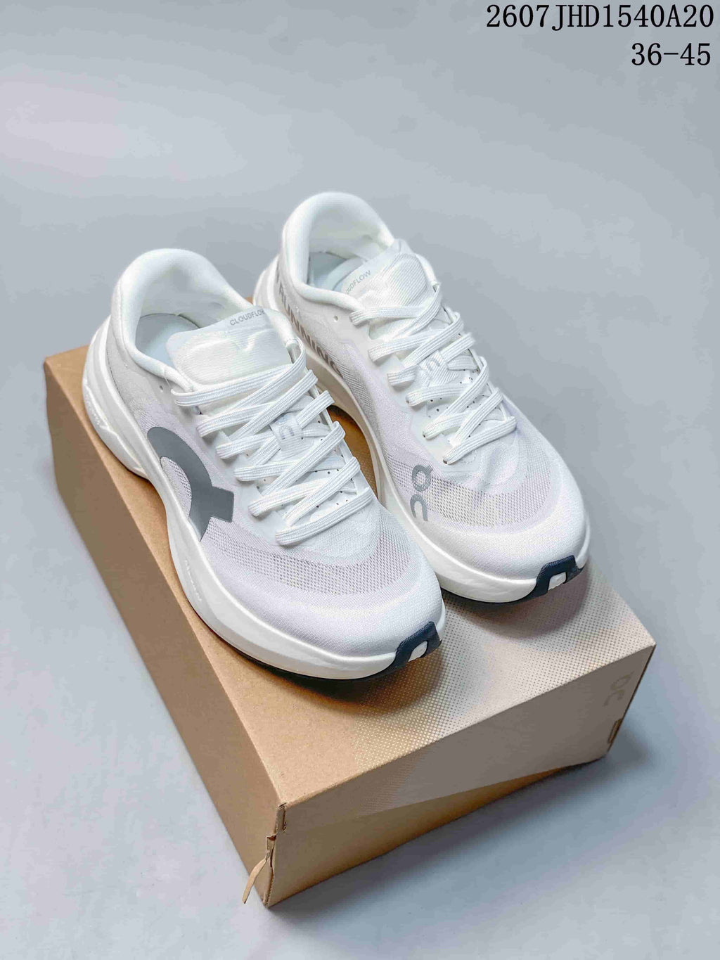 Pair of white and gray On low-top sneakers displayed on a shoebox, with style code JHD1540A20 and size range 36–45 visible at the top.