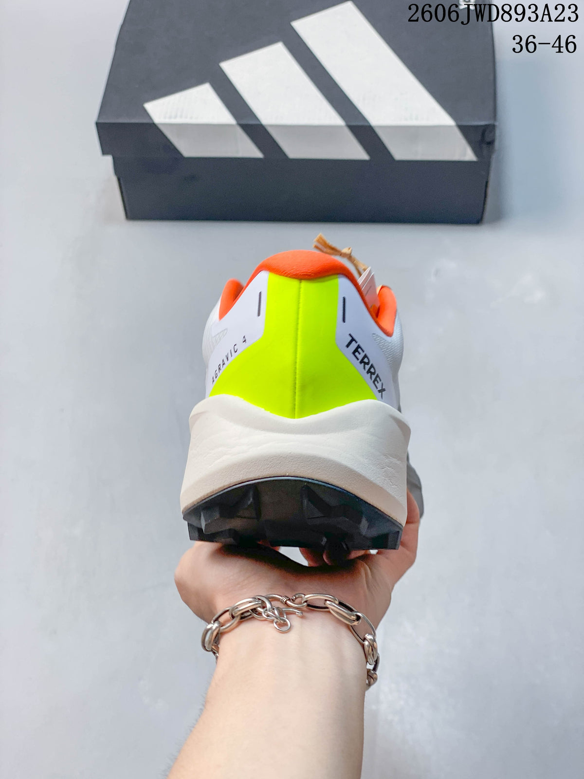 Rear view showing the shoes' neon yellow heel panels and orange collar lining.