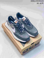 Pair of dark gray and white Nike ACG LDV sneakers displayed on an ACG shoebox.