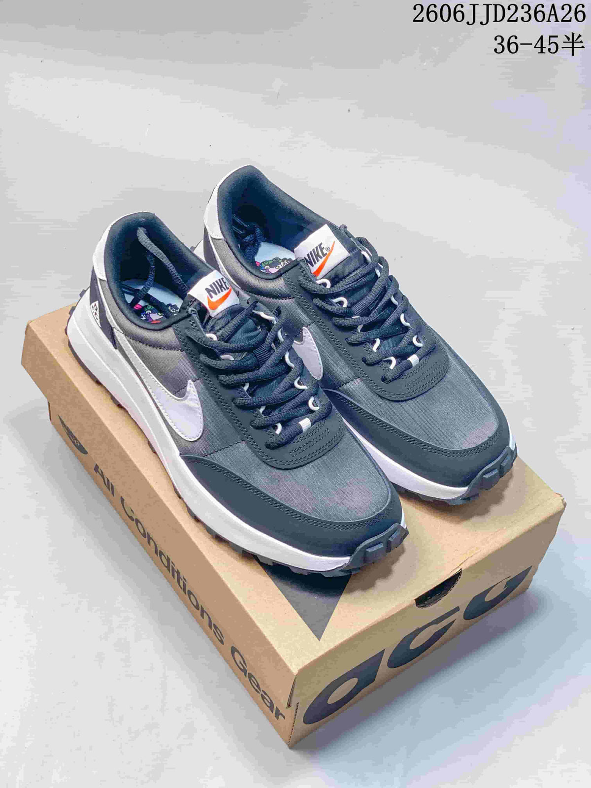 Pair of dark gray and white Nike ACG LDV sneakers displayed on an ACG shoebox.