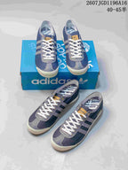 Multiple views of blue adidas Spezial sneakers arranged around an adidas shoebox, showing the low-top silhouette and white laces.