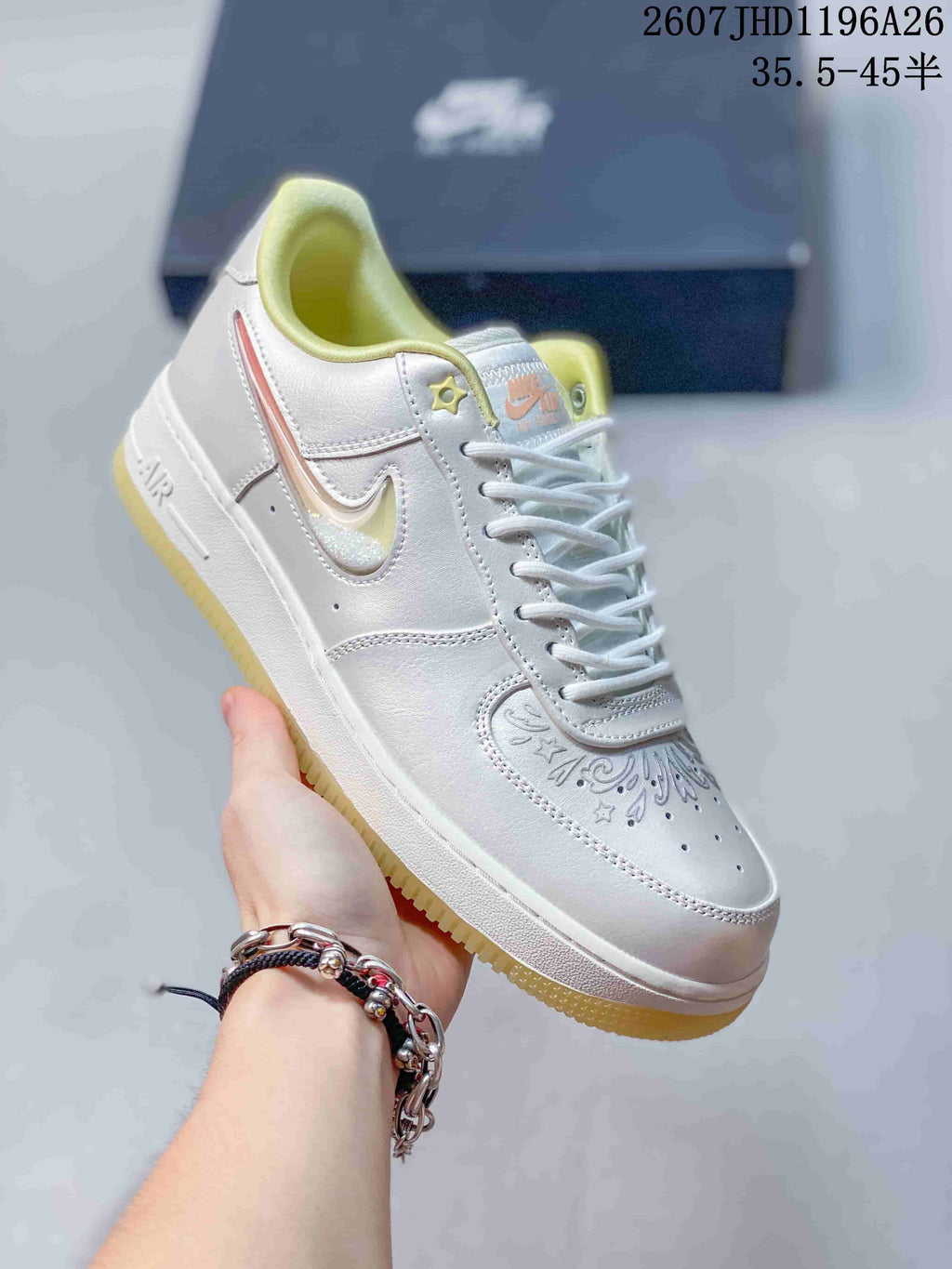 Angled side view of the white sneaker showing the Swoosh, decorative toe pattern, padded collar, and yellow outsole.