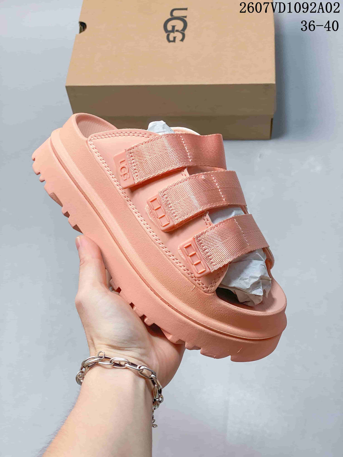Coral pink slide sandal with three wide straps and a raised, ridged sole.