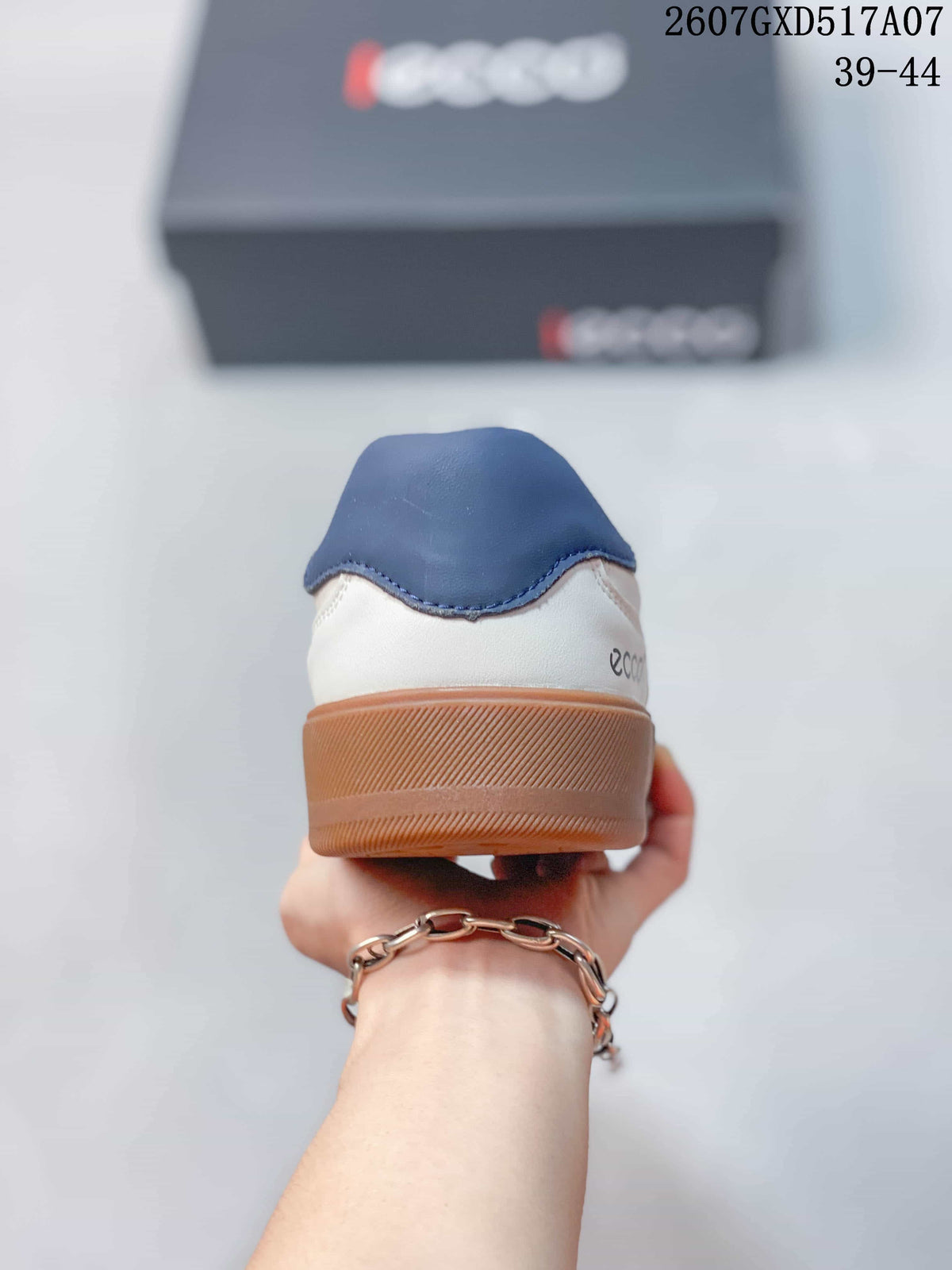 Rear view of the white sneaker showing the navy heel collar, white heel panel, and gum-colored outsole; style code 2607GXD517A07 and size range 39-44 are visible.