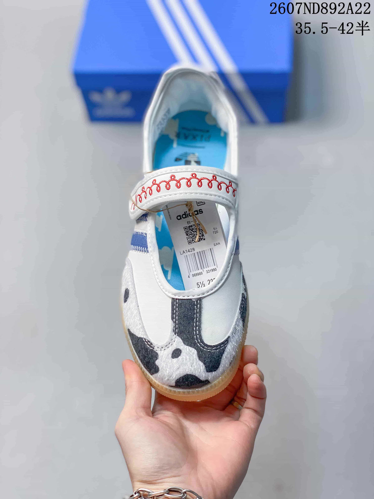 Top view of the sneaker showing the Mary Jane-style strap, patterned toe, blue insole, and product label.