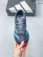 Top view of the lace-up sneaker showing the gray tongue, blue branding and textured toe area.