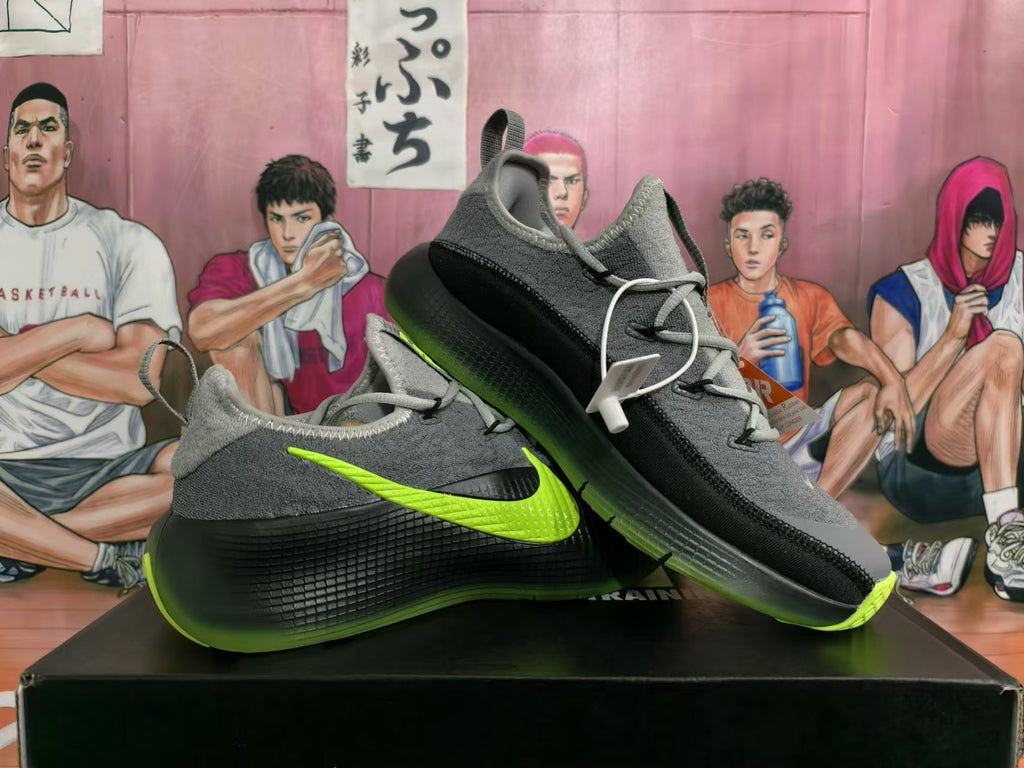 Pair of gray Nike low-top sneakers with black panels and lime-green accents