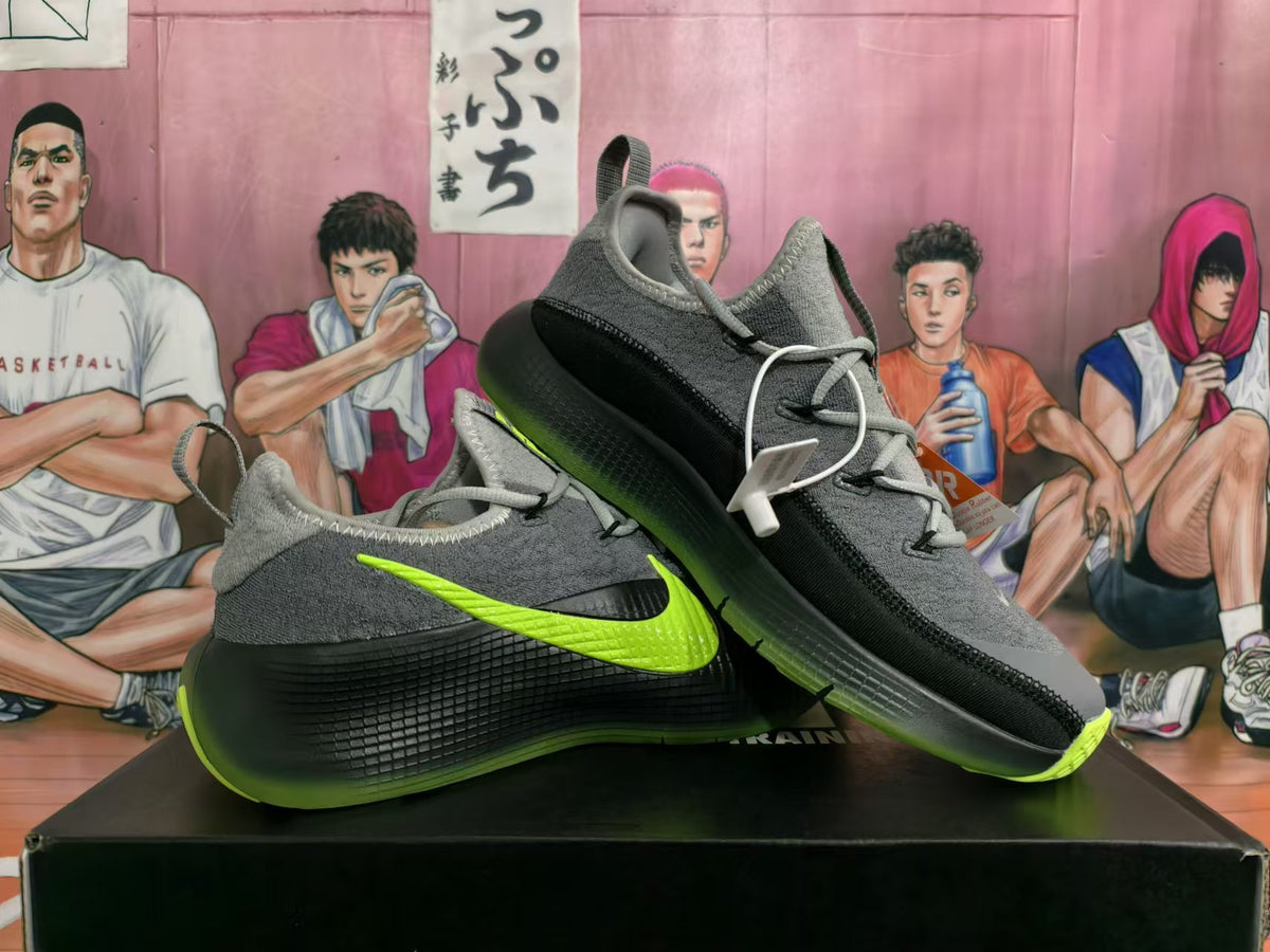 Pair of gray Nike low-top sneakers with black panels and lime-green accents