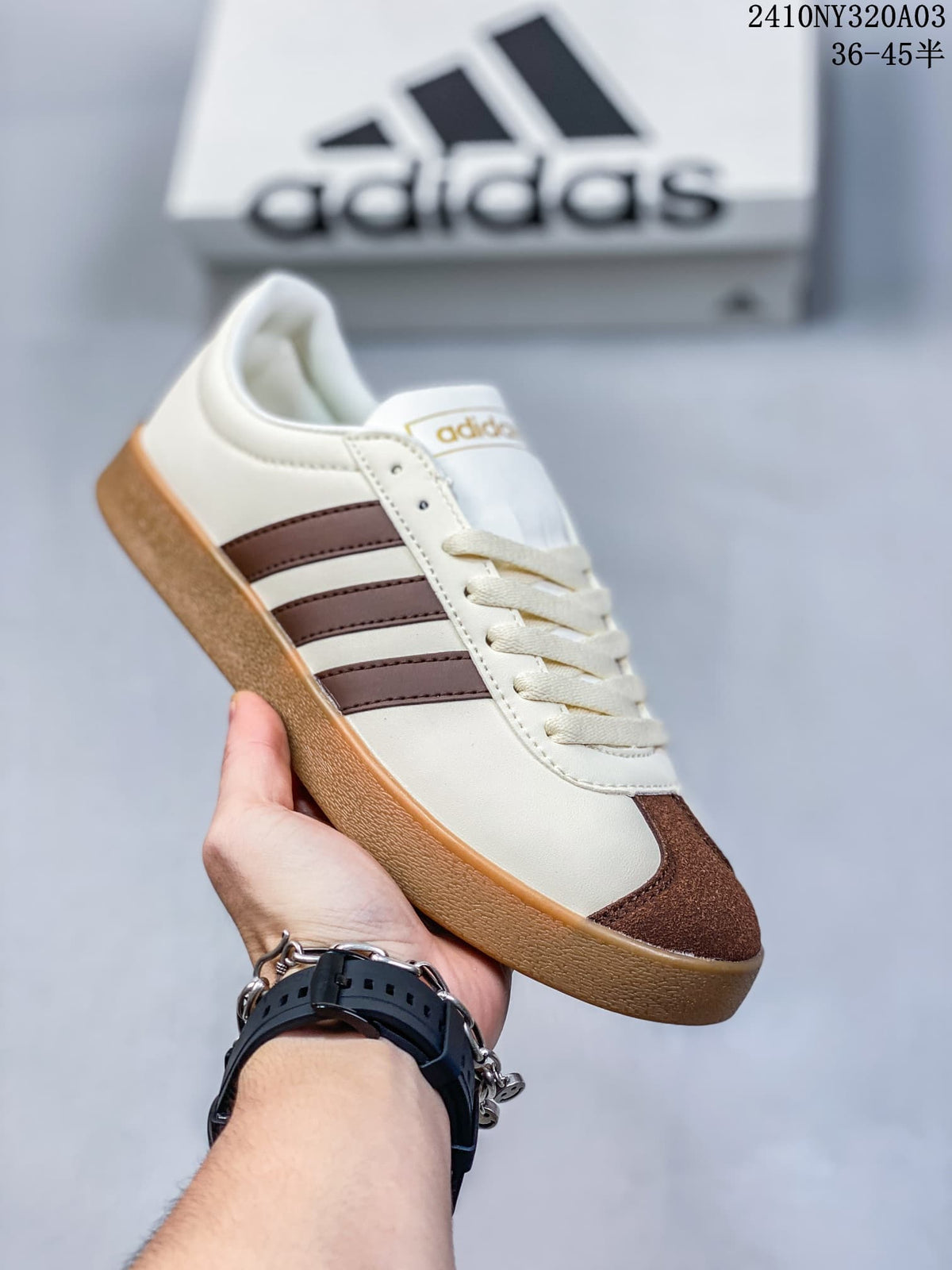 Angled side view of the white and brown Adidas low-top sneaker with a gum-colored outsole.