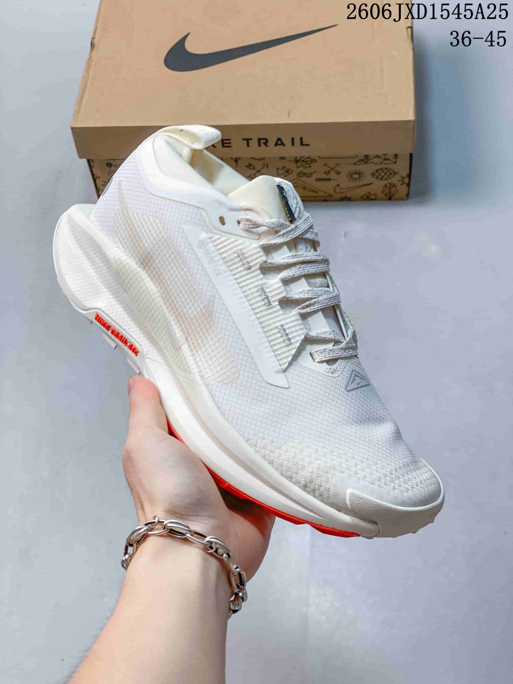 Angled side view of the white shoe with red outsole accents
