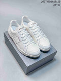 Pair of white Prada Downtown low-top sneakers displayed on a shoebox, with style code 2607HXD1829A19 and size range 38–45 visible above.