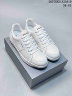 Pair of white Prada Downtown low-top sneakers displayed on a shoebox, with style code 2607HXD1829A19 and size range 38–45 visible above.