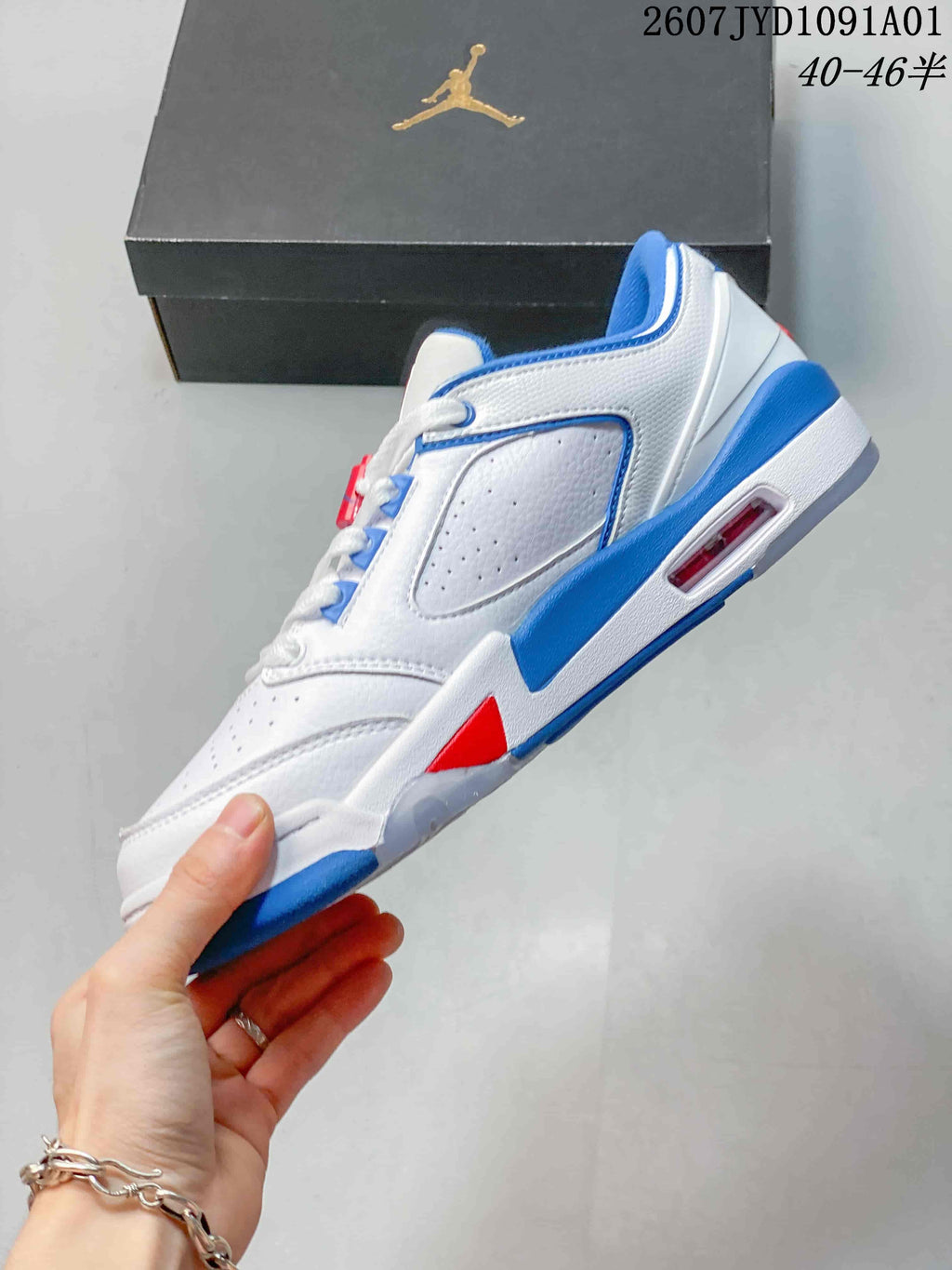 Side profile showing the white upper, blue and red accents, and visible midsole window