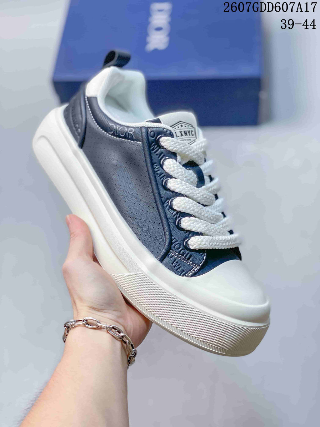 Angled side view showing the navy and white upper, Dior branding detail, laces, and raised sole.