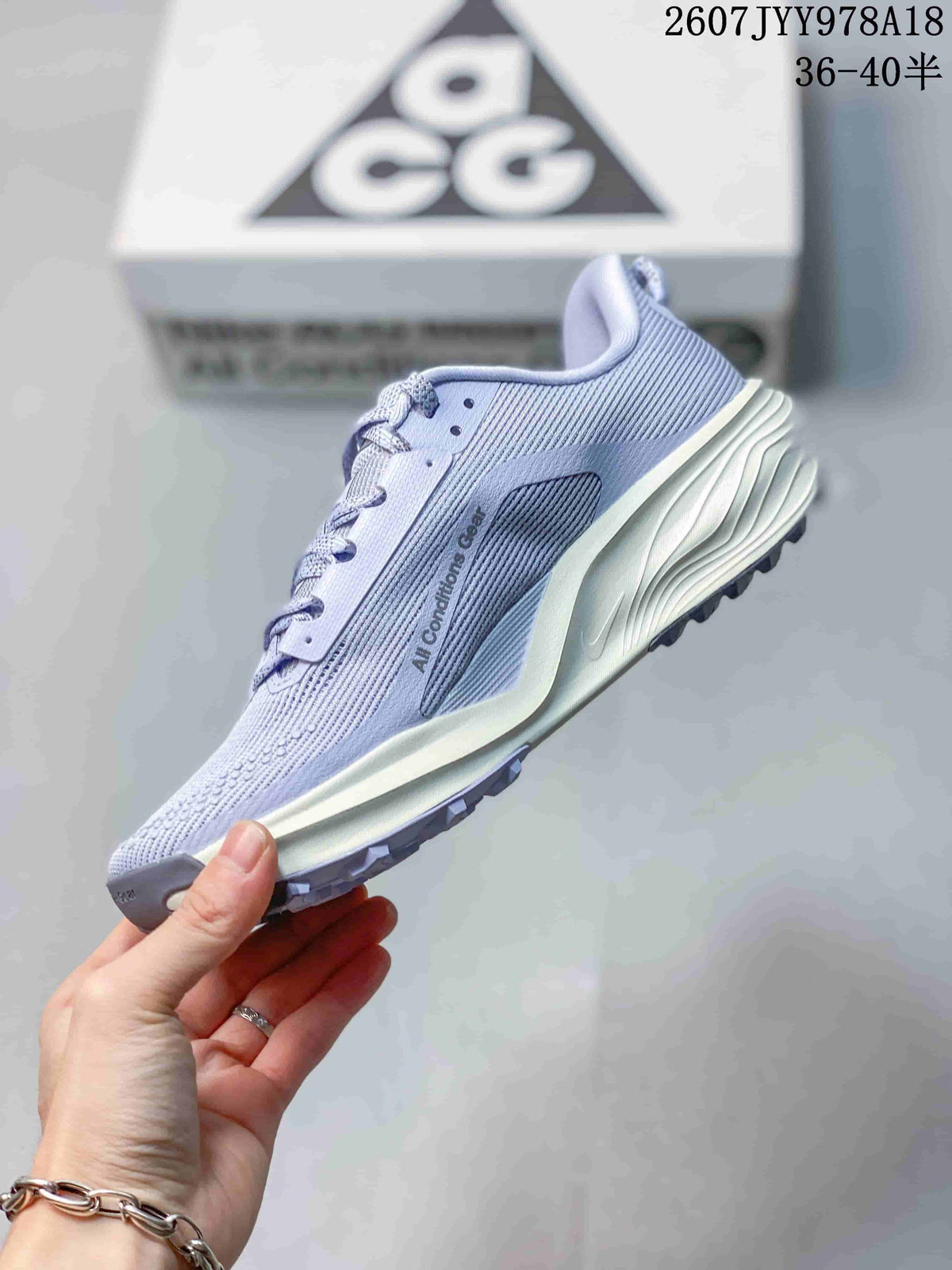 Side profile of a lavender Nike ACG Pegasus Trail sneaker showing the Nike Swoosh, textured upper, cream midsole, and lugged outsole.