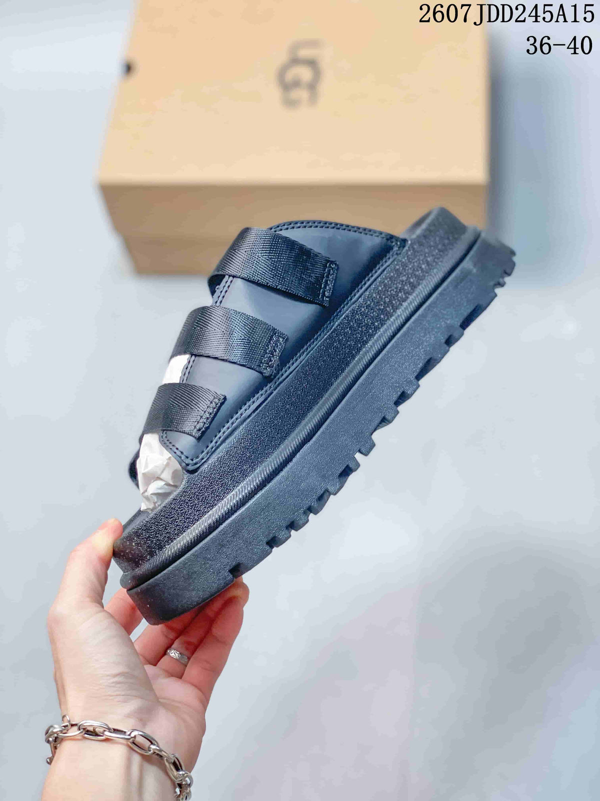 Side view of a black platform slide sandal showing the three straps and thick lugged outsole.