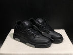 Front three-quarter view of the black sneaker pair with tonal laces, perforated toe panels and attached hangtag.