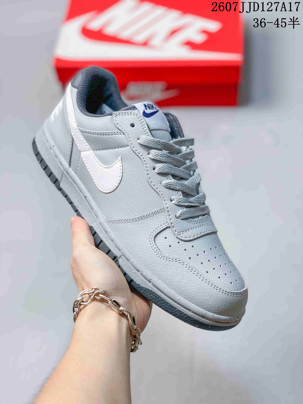 Light gray and white Nike SB Dunk Low Pro sneaker with a white Swoosh and gray outsole.